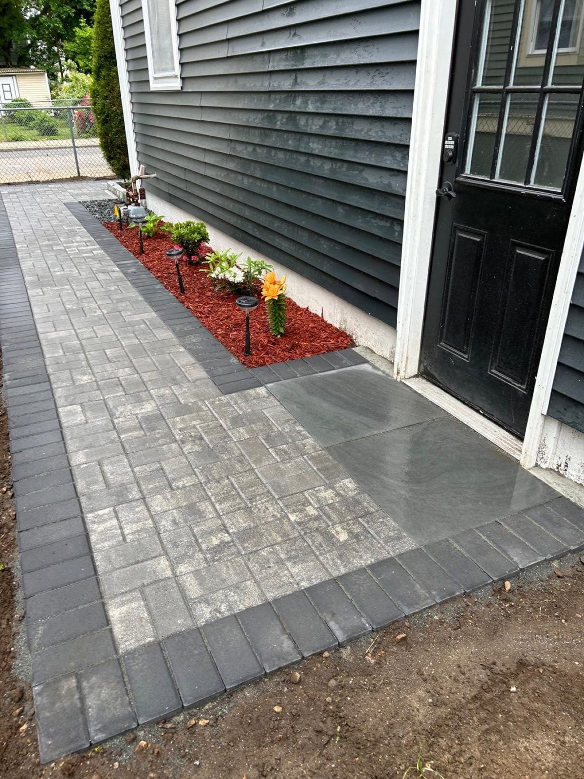 Paver walkway and bluestone landing leading to a home entrance, built by Levi Construction
